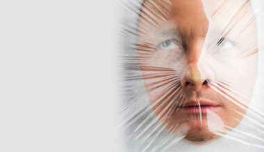 Face in hood behind sheet of plastic wrap