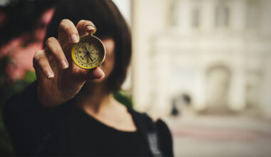 woman holding a compass in front of her face