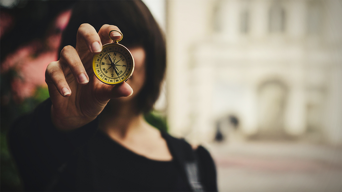 woman holding a compass in front of her face