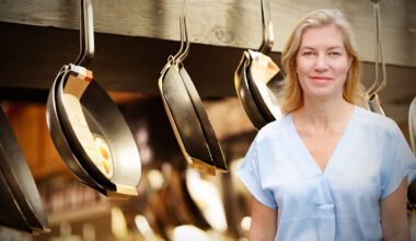 Anne-Sofie Bäckar in front of hanging frying pans